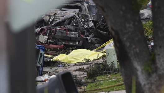 Authorities work the scene where a small plane crashed into a San Diego neighborhood, setting several homes on fire and forcing evacuations along several blocks early Thursday, May 22, 2025. (AP Photo/Gregory Bull) Associated Press / LaPresse Only italy and spain